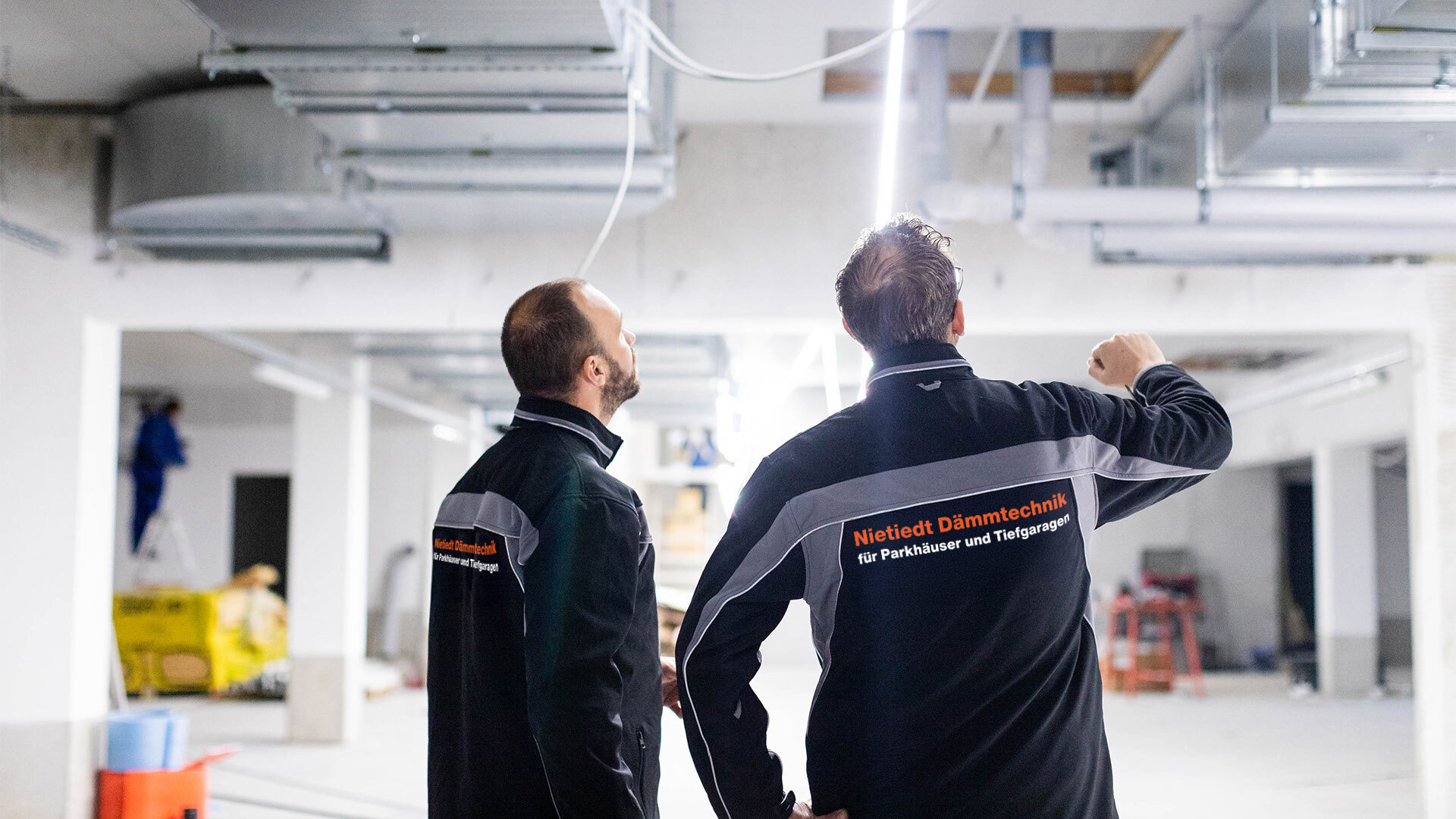 Nietiedt Mitarbeiter vor einer Planungskizze auf einer Tiefgaragenbaustelle